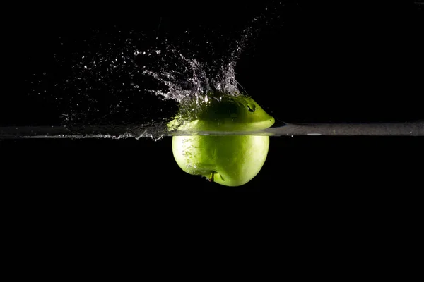 Primo Piano Una Mela Verde Acqua Con Spruzzi Uno Sfondo — Foto Stock