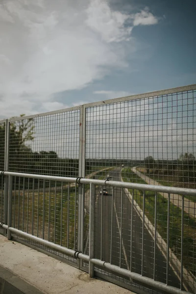 穿过乡间空旷街道上方一座桥上金属栅栏的景观 — 图库照片