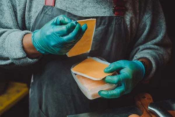 A person using cheese for making burgers