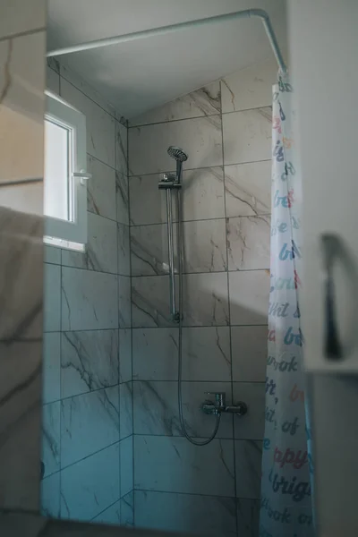 Pionowe Ujęcie Wnętrza Łazienki Prysznicem Marmurowymi Płytkami — Zdjęcie stockowe