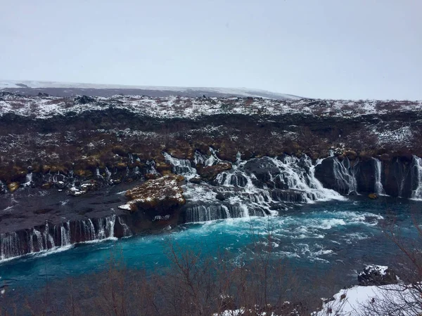 Uma Vista Hipnotizante Cachoeira Hraunfossar Dia Gelado Neve Inverno — Fotografia de Stock