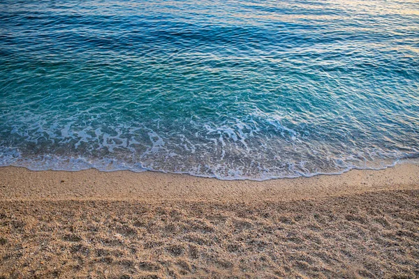 晴れた日には波がゆらめく砂浜の高い角度のショット — ストック写真