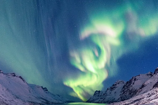 ノルウェーのトロムソで夜に湖や岩の多い丘の上のオーロラの風景 — ストック写真