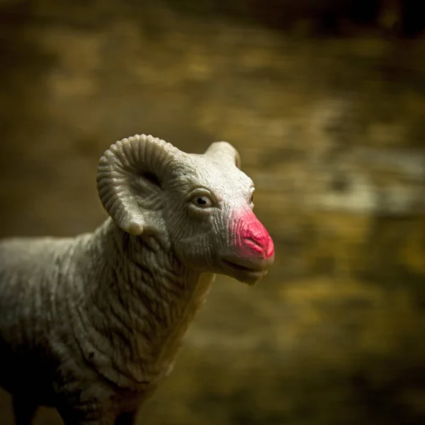 Eine Nahaufnahme Einer Schafsfigur Mit Pinkfarbener Nase Vor Braun Verschwommenem — Stockfoto