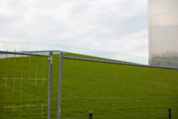 牧草地の背景に金属線フェンスの選択的な焦点 — ストック写真