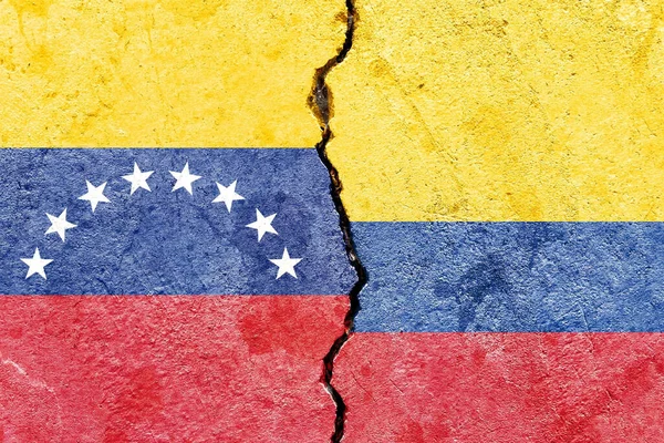 ベネズエラの旗とコロンビアの旗が壁の背景に割れている — ストック写真