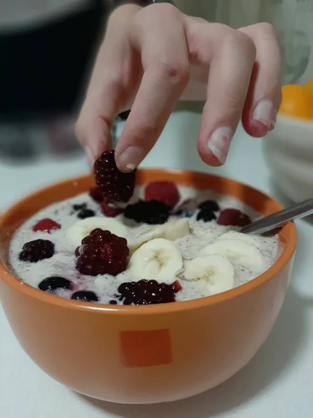 Aki Joghurtot Eszik Banánszeletekkel Málnával Reggelire — Stock Fotó