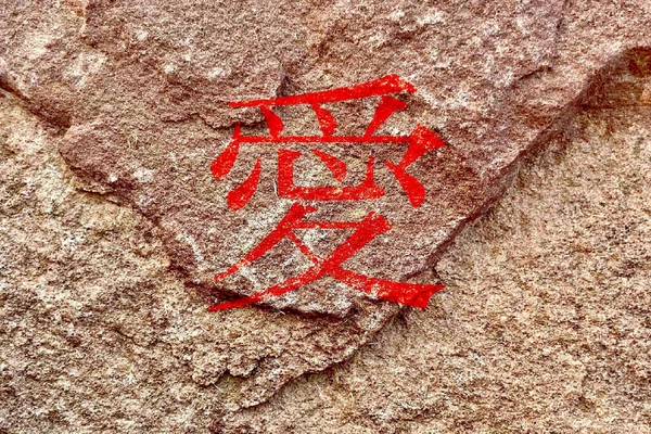 中国の伝統的な愛の文字は風化した岩壁の背景に隔離された — ストック写真