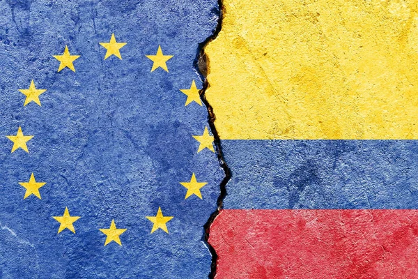 欧州連合の旗とコロンビアの旗は壁の背景に亀裂が入り — ストック写真