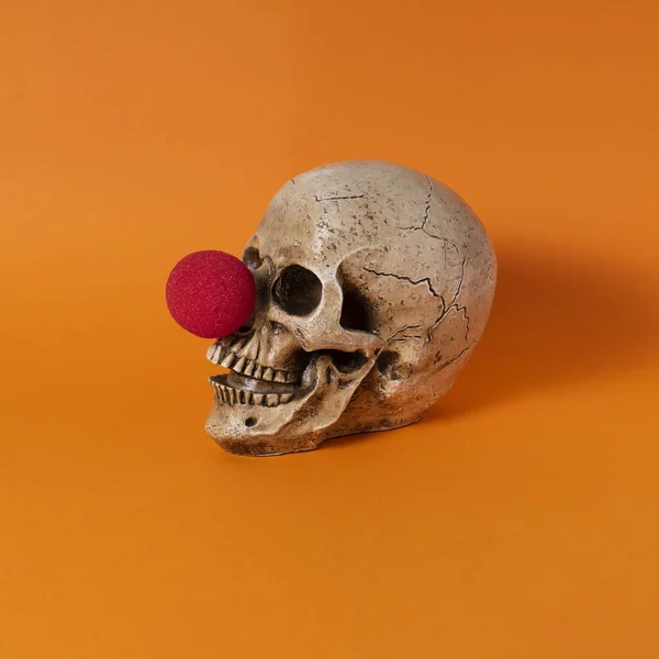 Kreativ Bild Skalle Med Röd Clown Näsa Orange Bakgrund — Stockfoto