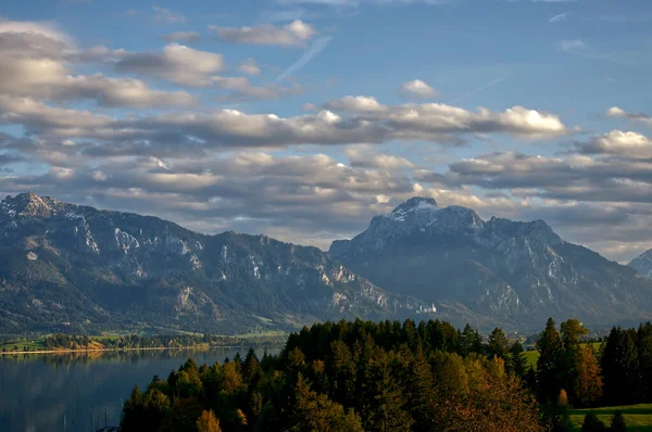 ドイツのアルガウにあるフォルゲンゼー湖の横にある山の上の美しい雲に満ちた空 — ストック写真