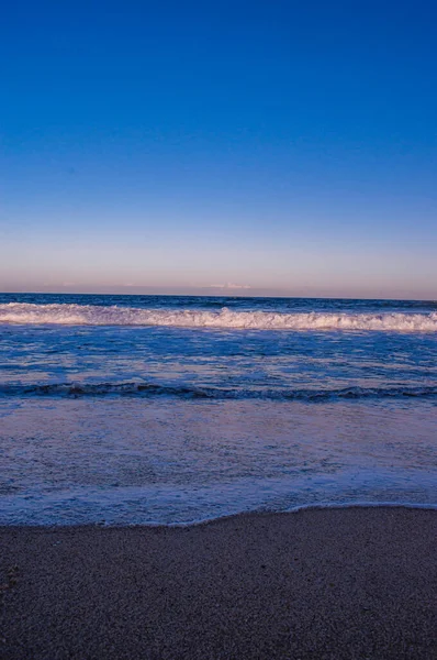 Вертикальный Снимок Пляжа Ясным Небом Вечером — стоковое фото
