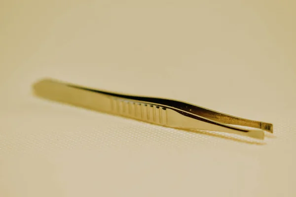 Closeup Golden Tweezers Beige Background — Stock Photo, Image