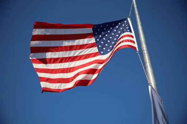 カンザス州オ旋盤のアーニー ミラーで青い空にアメリカの旗を振っての低角度ショット — ストック写真