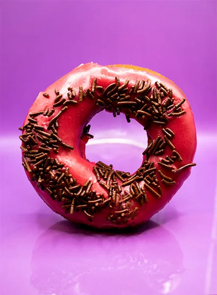 Donut Rosa Com Pepitas Chocolate Refletindo Sobre Superfície Rosa — Fotografia de Stock