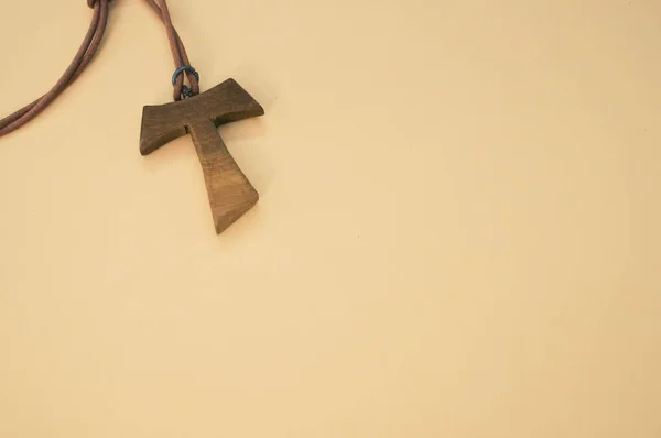 Zbliżenie Ujęcie Drewnianego Naszyjnika Krzyża Tau Odizolowanego Brązowym Tle — Zdjęcie stockowe