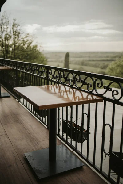 Drewniany Stół Balkonie Żelaznym Ogrodzeniem — Zdjęcie stockowe