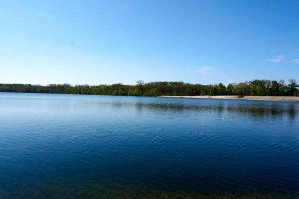 Lago Calmo Sotto Cielo Blu Con Alberi Sullo Sfondo — Foto Stock
