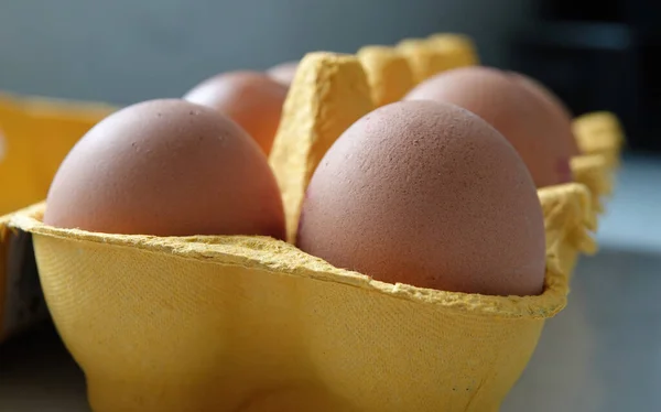 A closeup of eggs in a yellow egg carton