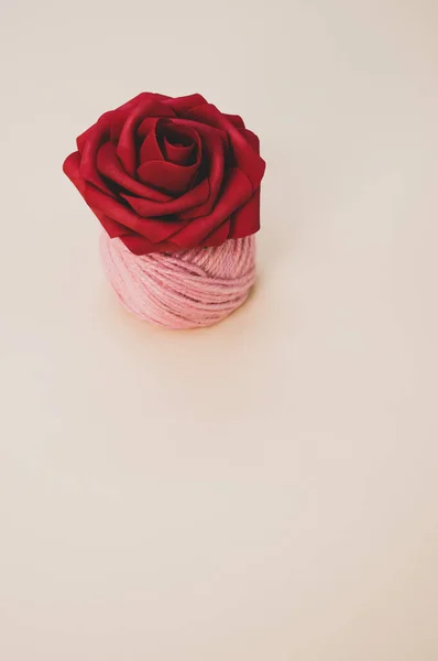 Vertikální Záběr Umělé Červené Růže Vlákno Cívky Pastelové Broskve Povrchu — Stock fotografie