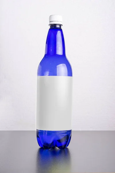 Tiro Vertical Uma Garrafa Azul Com Rótulo Uma Superfície Mesa — Fotografia de Stock