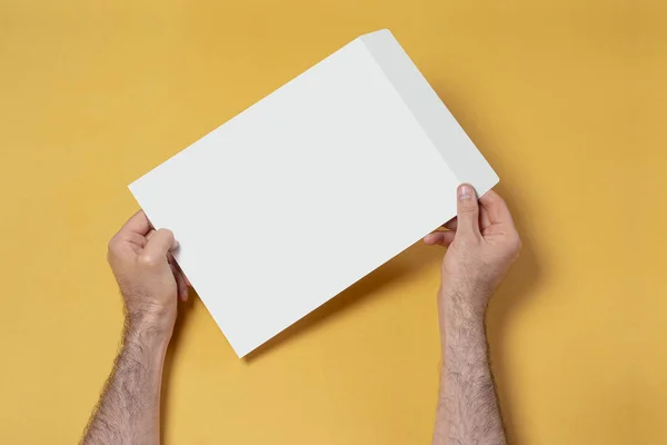 Zdjęcie Bliska Męskiej Ręki Trzymającej Papierową Kopertę Żółtym Tle — Zdjęcie stockowe