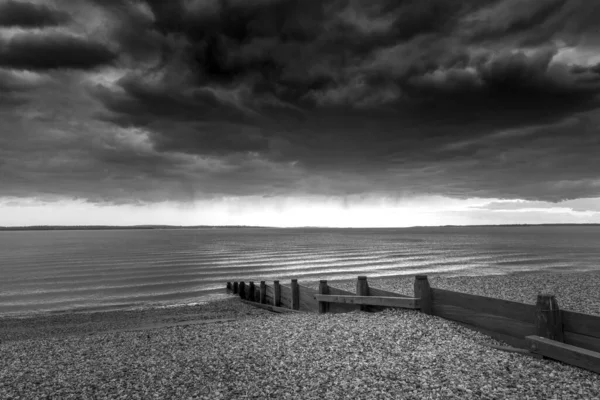 Eine Horizontale Monochrome Aufnahme Eines Hölzernen Groynes Einem Strand Unter — Stockfoto