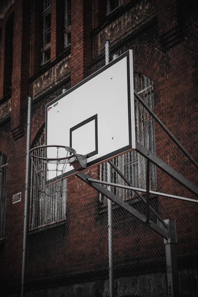 Вертикальный Снимок Баскетбольного Кольца Корзиной Рядом Красным Зданием — стоковое фото