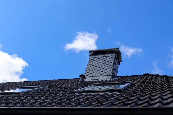 在乌云密布的蓝天下一幢房子的黑色黏土瓦屋顶的低角 — 图库照片