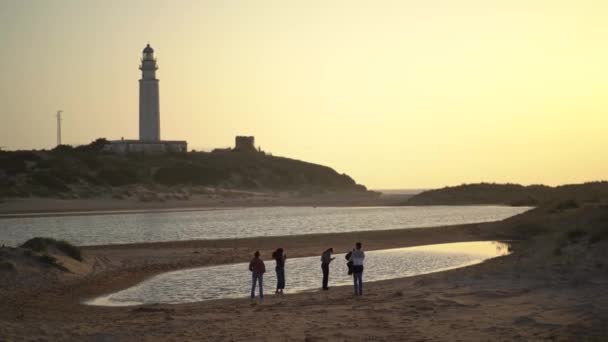 Group Friends Posing Having Fun Sandy Coast Lighthouse Background — Stock Video