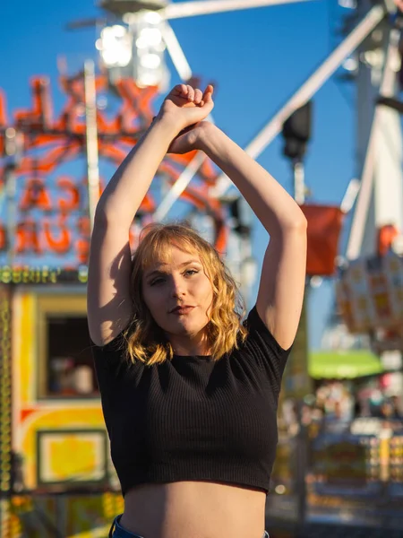 Pionowe Ujęcie Młodej Blondynki Szczęśliwej Kobiety Pozującej Parku Rozrywki — Zdjęcie stockowe