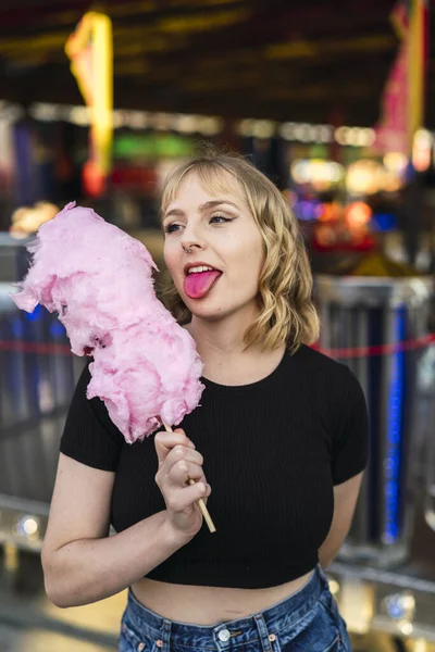 一个年轻快乐的白人女人吃棉花糖 在游乐园里玩得很开心 — 图库照片