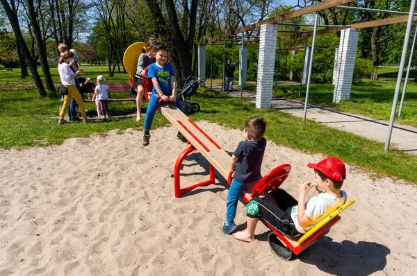 Poznan ポーランド 2021年5月9日 公園の晴れた春の日に遊び場でシーソーに座っている4人の子供 — ストック写真