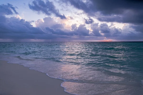 地平線の太陽と曇りの天気で砂浜の波 — ストック写真