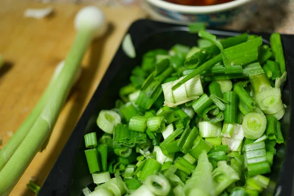 Een Close Shot Van Gehakte Groene Uien Een Zwarte Plaat — Stockfoto