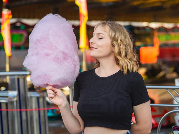 Uma Jovem Mulher Loira Comendo Grandes Doces Algodão Parque Diversões — Fotografia de Stock