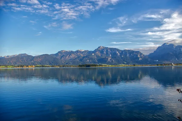 ドイツのアルガウにある鏡のようなフォルゲンゼー湖に映る岩山の絶景 — ストック写真