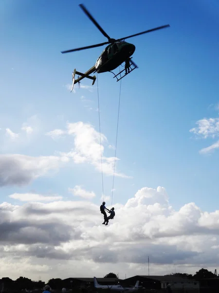 Eine Vertikale Aufnahme Von Zwei Männern Die Aus Einem Hubschrauber — Stockfoto