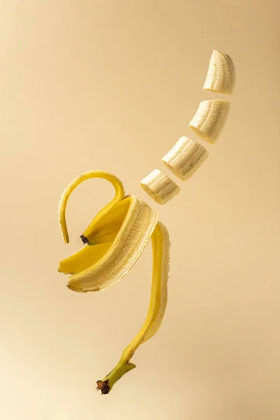 베이지 배경에 공기중에서 바나나를 — 스톡 사진