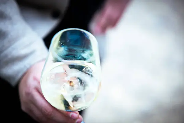 Ręka Trzymająca Szklankę Białego Wina Rozmytym Tle — Zdjęcie stockowe