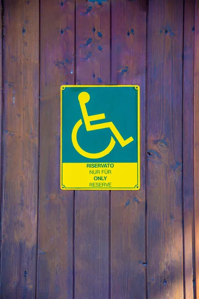 轮椅使用者卫生间的绿色黄色塑料标志 用几种语言标明仅供轮椅使用者使用 — 图库照片