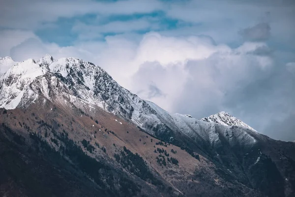 Een Adembenemend Uitzicht Besneeuwde Rotsachtige Bergen Onder Een Bewolkte Hemel — Stockfoto