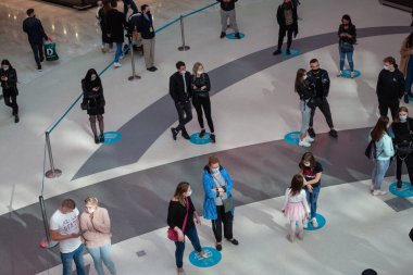POZNAN, POLAND - May 08, 2021: Social distancing people in the mall. Footprints on the floor to keep distance. Top view clipart