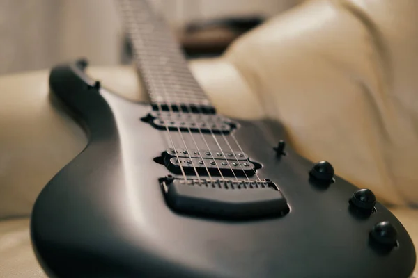 Μια Επιλεκτική Φωτογραφία Ενός Μαύρου Electro Guitar Ένα Λευκό Καναπέ — Φωτογραφία Αρχείου