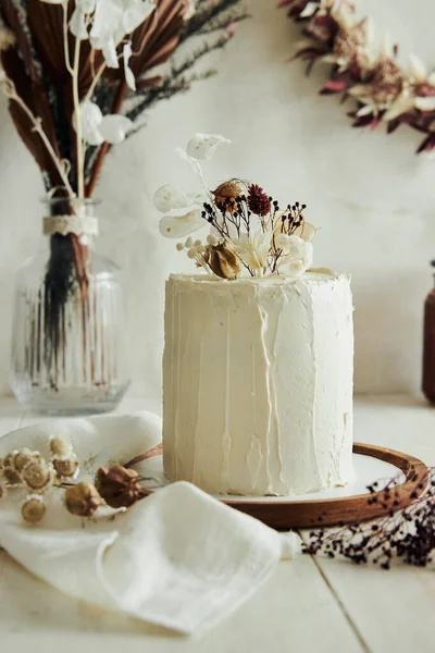 白いテーブルの上に乾燥した花とおいしいボホンブレケーキのクローズアップショット — ストック写真