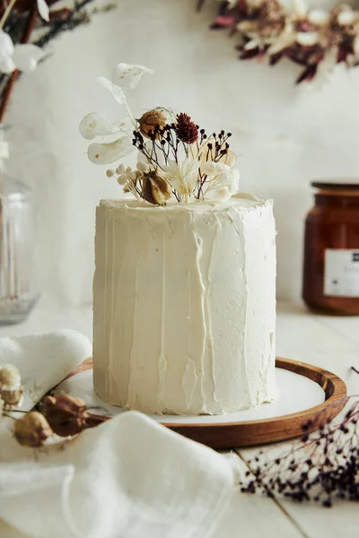 白いテーブルの上に乾燥した花とおいしいボホンブレケーキのクローズアップショット — ストック写真