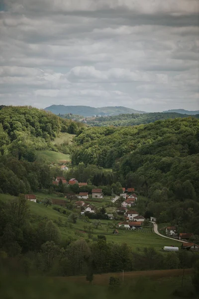 Ağaçlarla Kaplı Güzel Tepeler Parlak Bir Gökyüzünün Altında Bir Köy — Stok fotoğraf