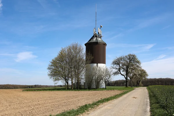 Voorjaarslandschap Met Watertoren Aan Weg — Stockfoto