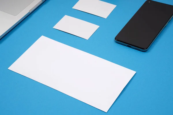 Closeup Laptop Smartphone Blank Pieces Paper Your Text Blue Background — Stock Photo, Image