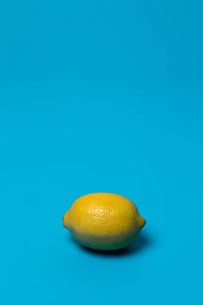 青い背景に黄色いレモンが1つ アナログ色 — ストック写真